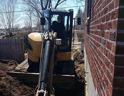 excavating house wall with cat305